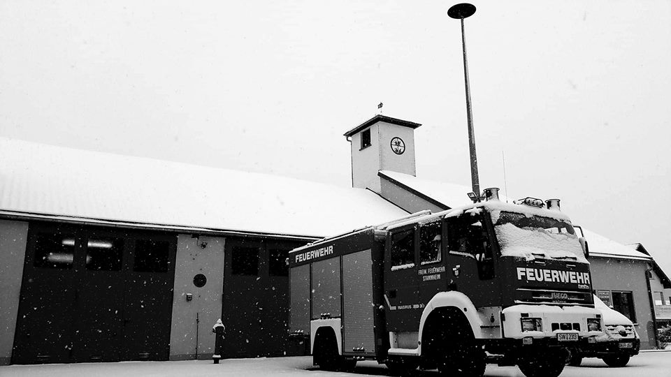 Verschneite Feuerwehrfahrzeuge auf dem Vorplatz